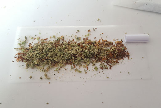De tip, tabak en verkruimelde wiet op de lange vloei. De tip, tabak en verkruimelde wiet op de lange vloei.