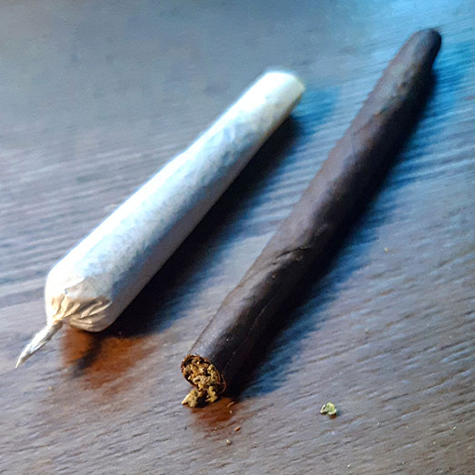 Een joint en blunt naast elkaar. Een joint en blunt naast elkaar.